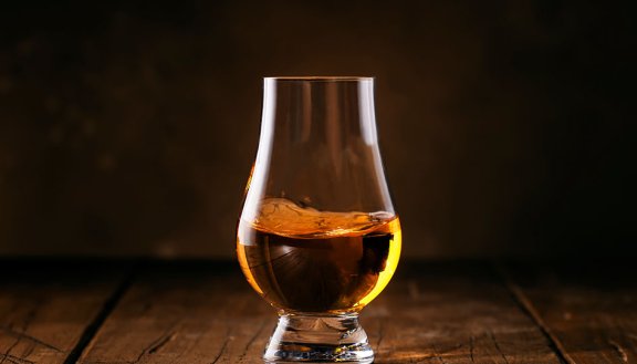 Scotch Whiskey without ice in glasses, rustic wood background, copy space